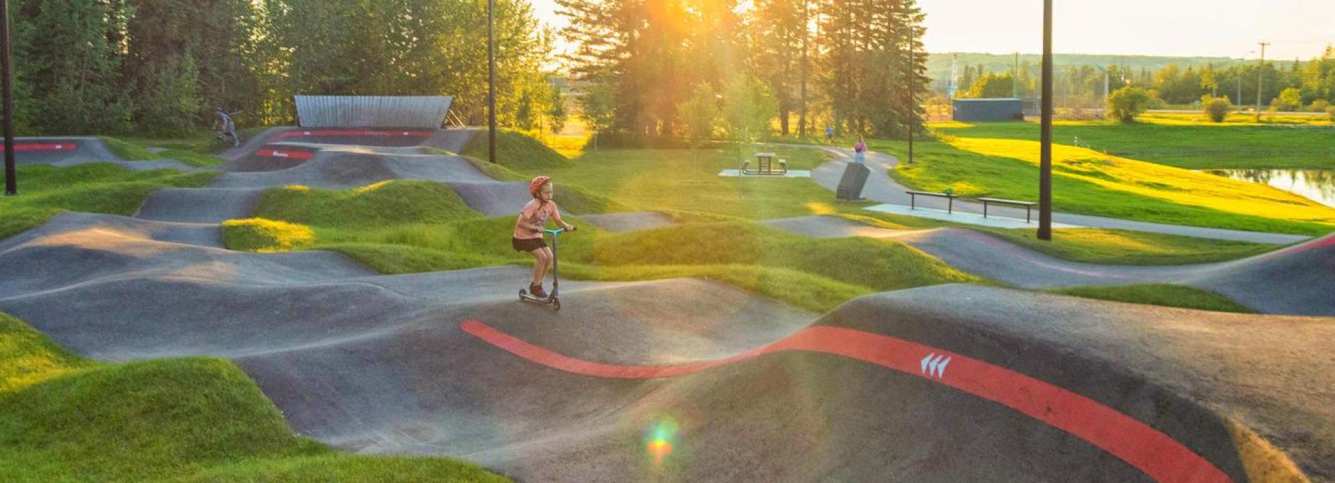 View of Kin Park with a child rollerblading and a sunset background