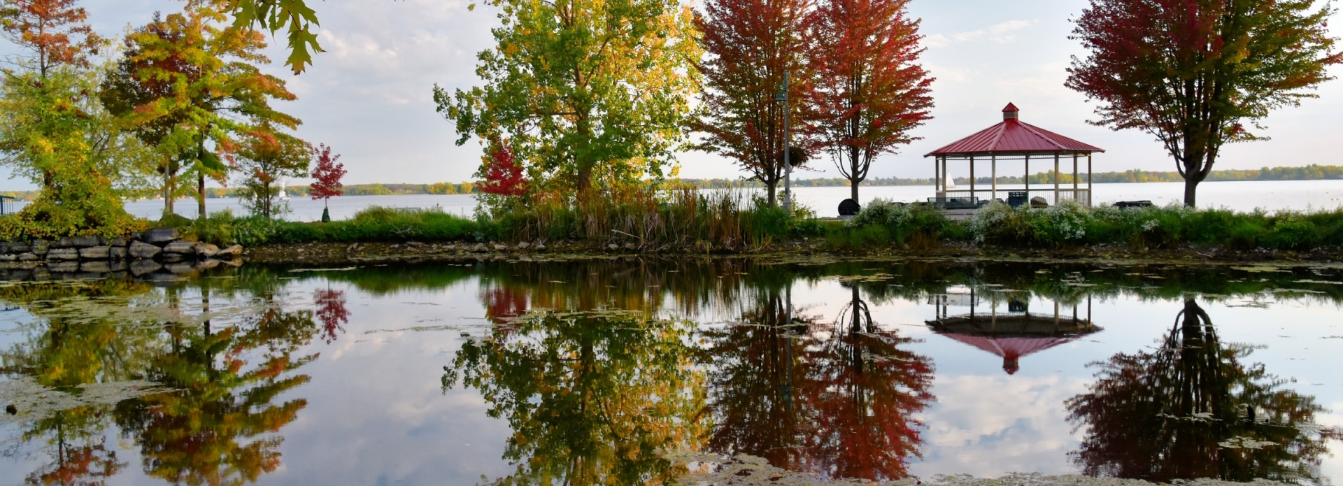 Colourful trees by the water with a gazebo. 