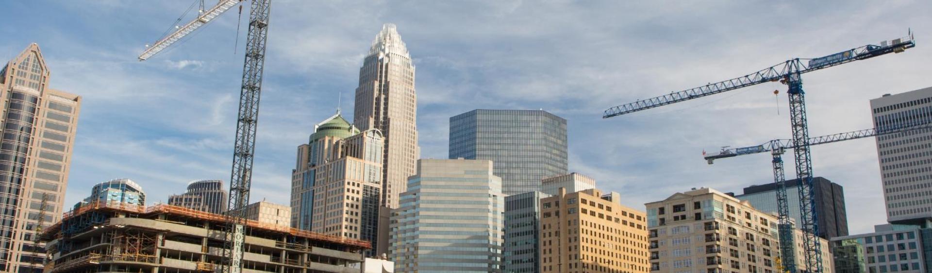 Panorama of a large city with multiple cranes set up