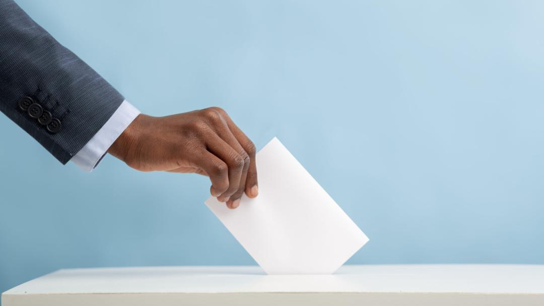 Hand putting a blank piece of paper into a box