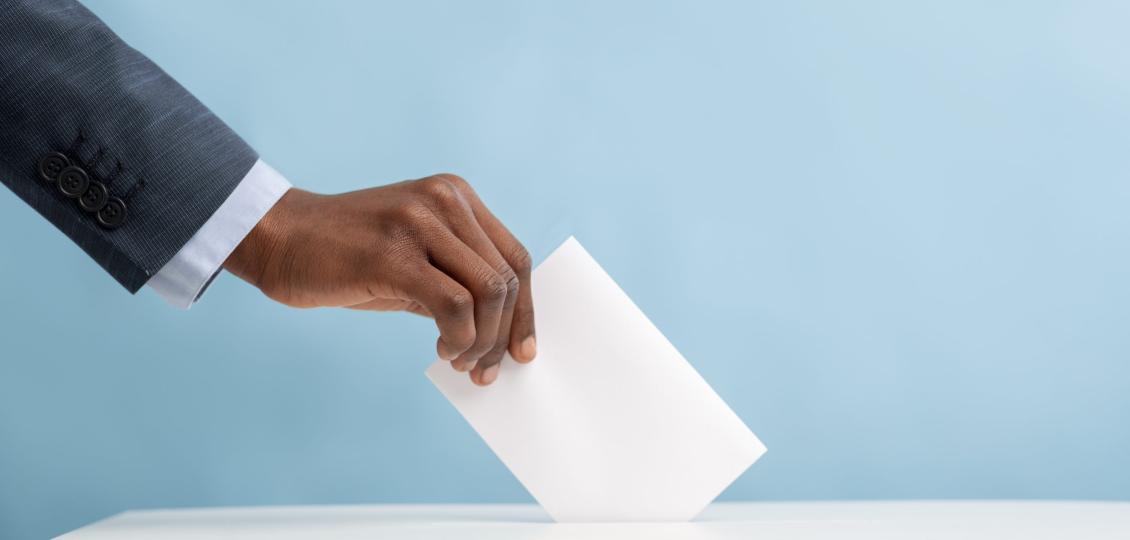 Hand putting a blank piece of paper into a box