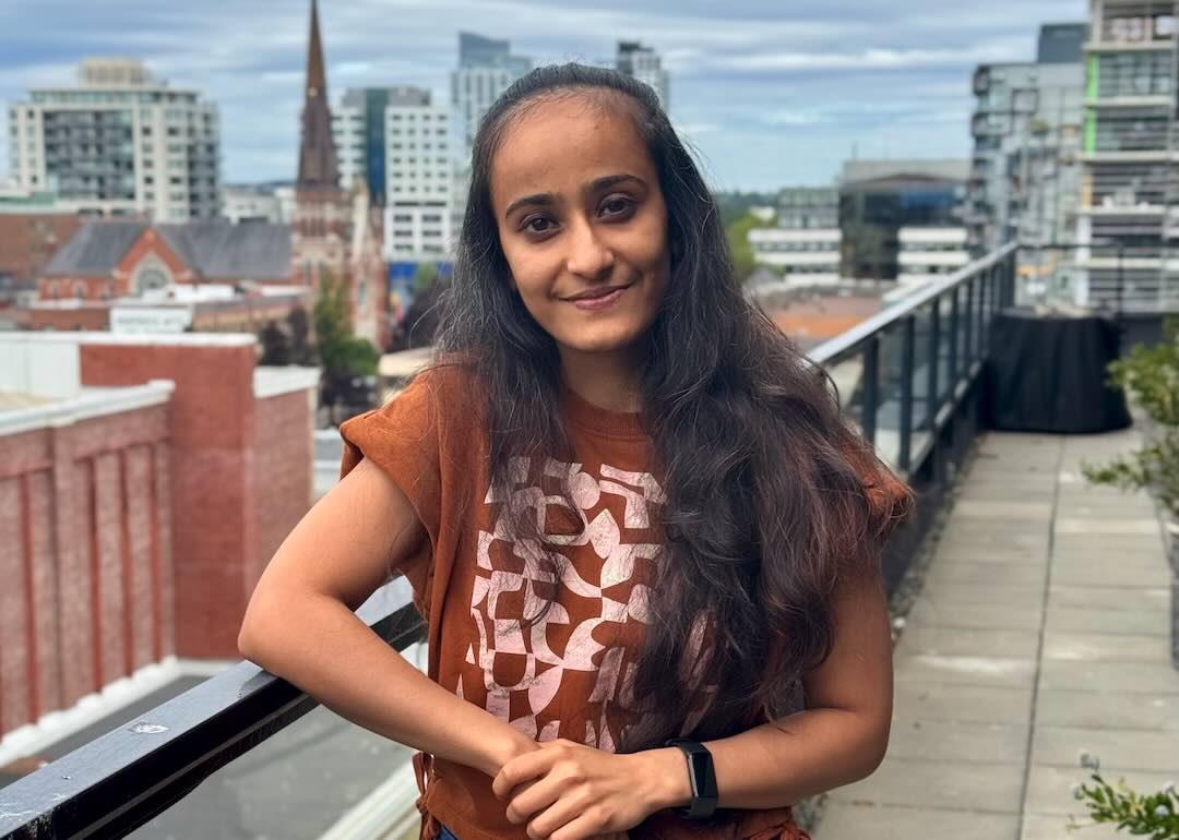 Dhara standing on a long balcony posing for a picture
