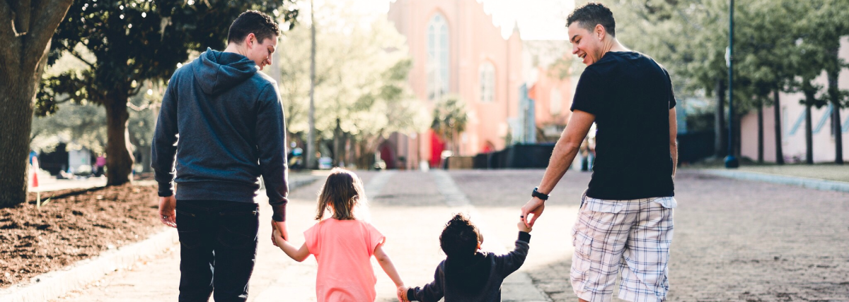Queer couple walking with their kids