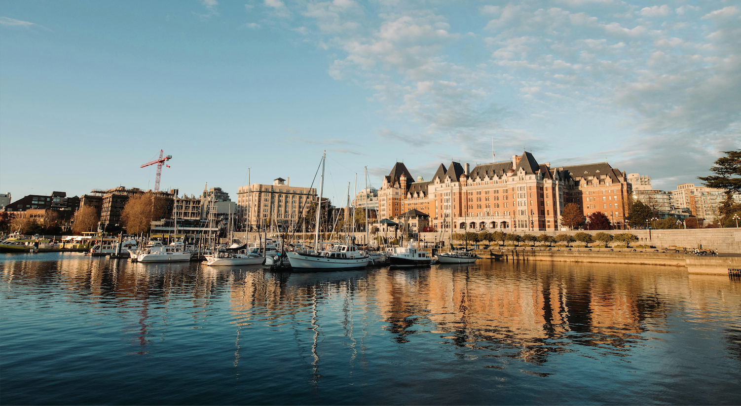A view across the Victoria harbour, towards downtown, looking at the sunset lighting up the Empress and the boats infront.