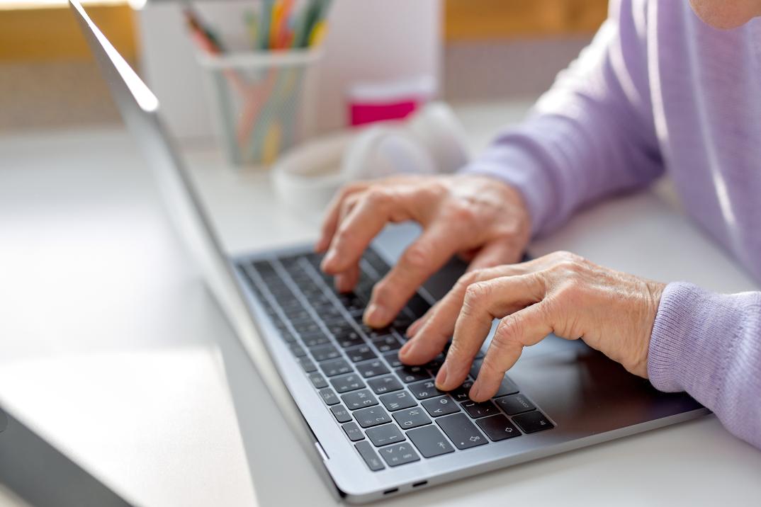 An elderly woman using a laptop.